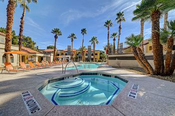 a swimming pool with palm trees and buildings in the background
